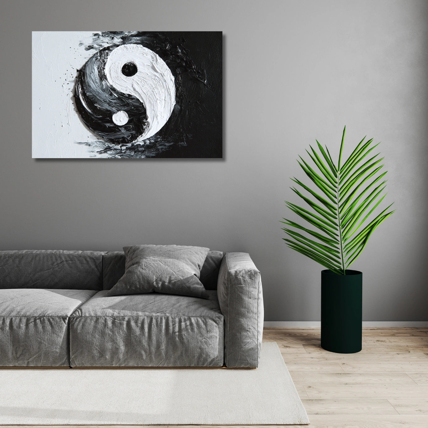 Living room with a gray sofa, yin yang wall art, and a potted plant.