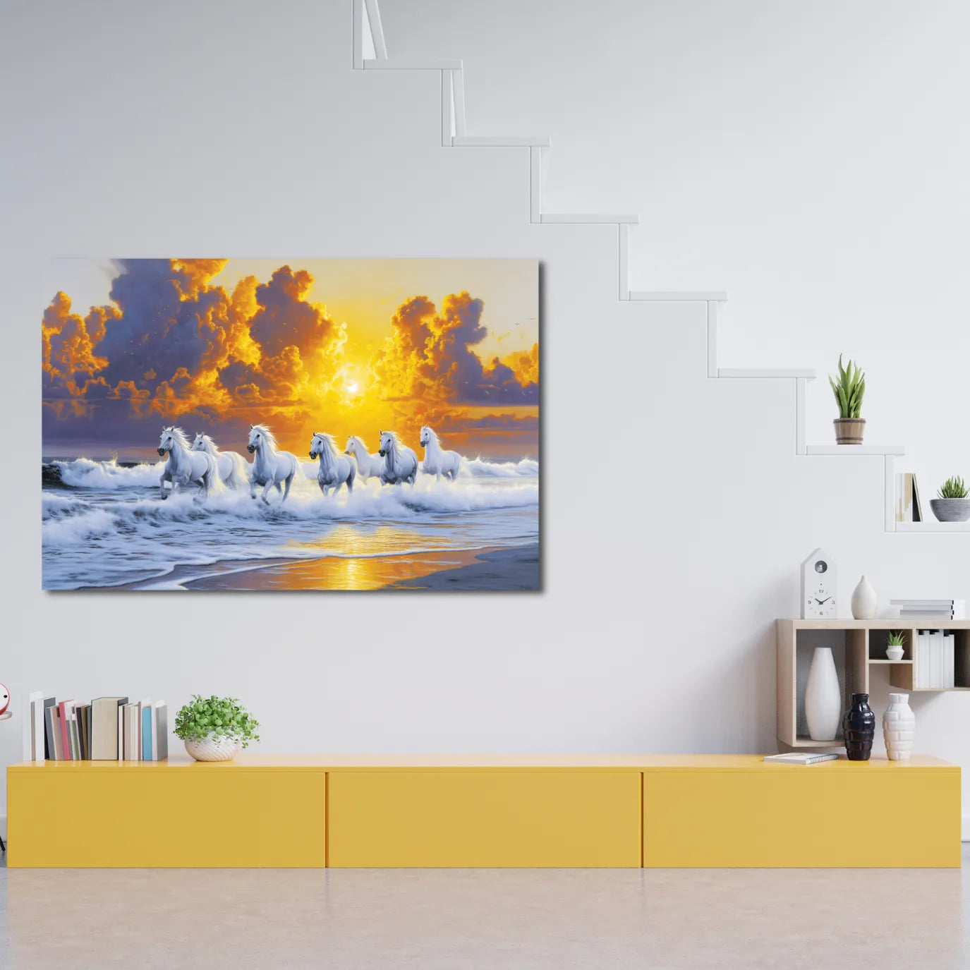 A canvas print of 7 horses on a beach at sunrise hanging above a yellow cabinet.