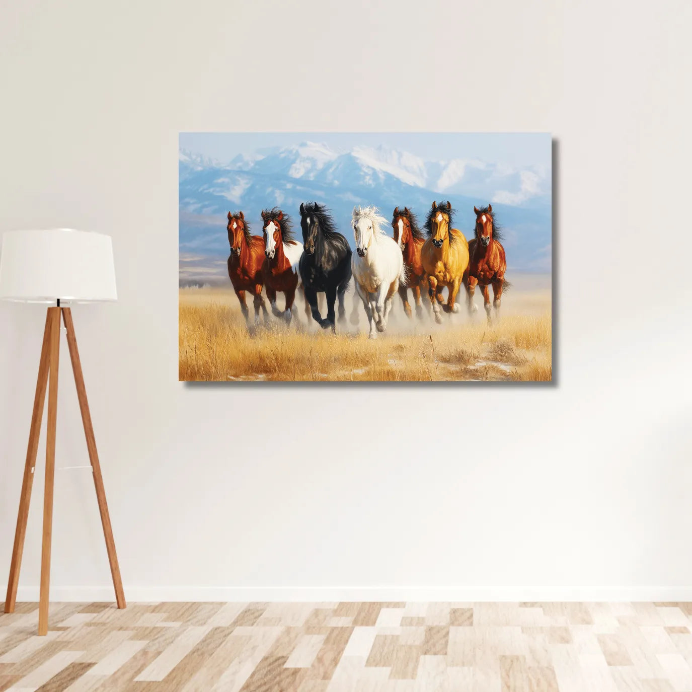 Canvas print of horses running in a field on a white wall with a lamp and wooden floor.