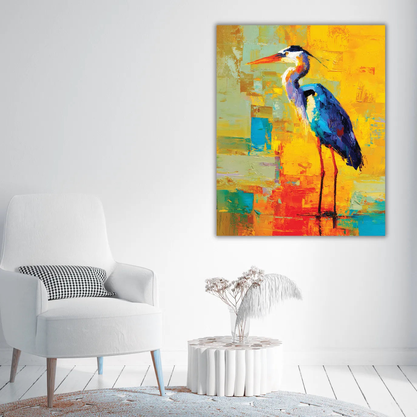 Colorful abstract painting of a heron on a white wall above a white chair.