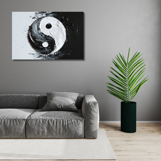 Living room with a gray sofa, yin yang wall art, and a potted plant.